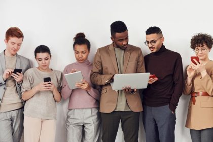 Grupo diverso de jovens usando dispositivos móveis em um ambiente interno.