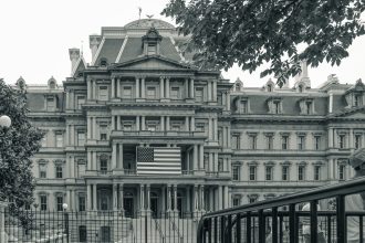 Edifício Eisenhower, em Washington, sede de escritórios do governo federal dos Estados Unidos, com uma bandeira americana em primeiro plano