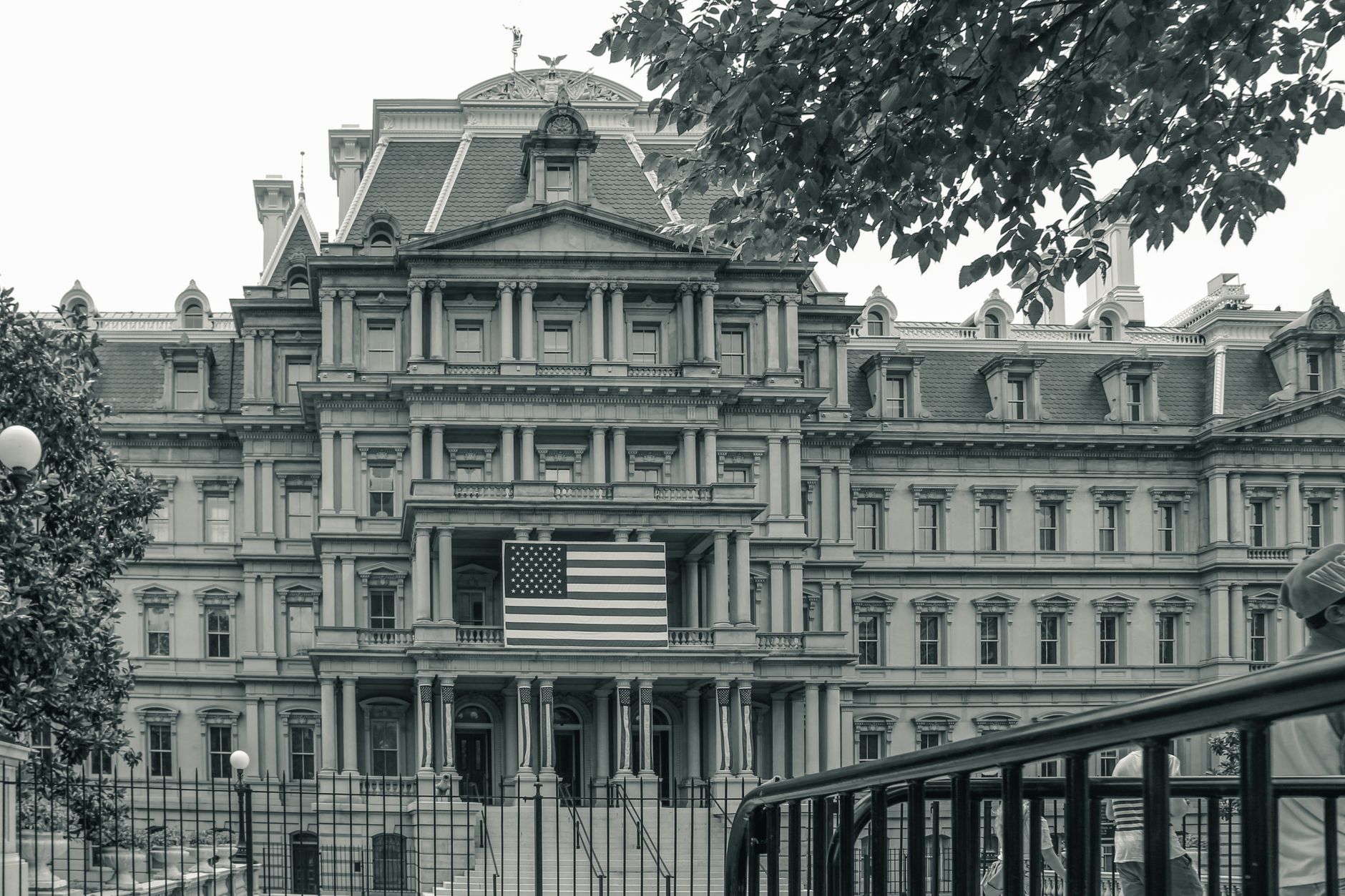 Edifício Eisenhower, em Washington, sede de escritórios do governo federal dos Estados Unidos, com uma bandeira americana em primeiro plano